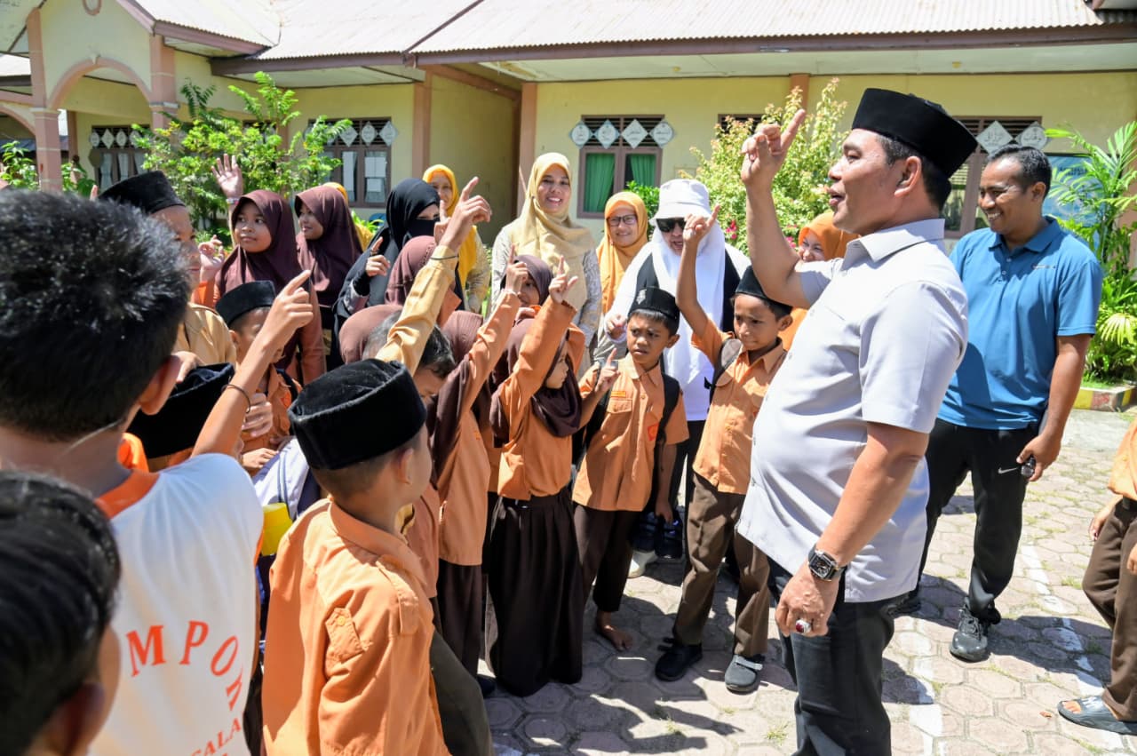 Bupati Aceh Besar Muharram Idris mengajak murid SDN Limpok menggunakan Bahasa Aceh